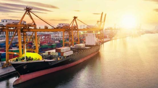 ©TotalEnergies, Adobestock 2023 Container vessel at birth with sunset